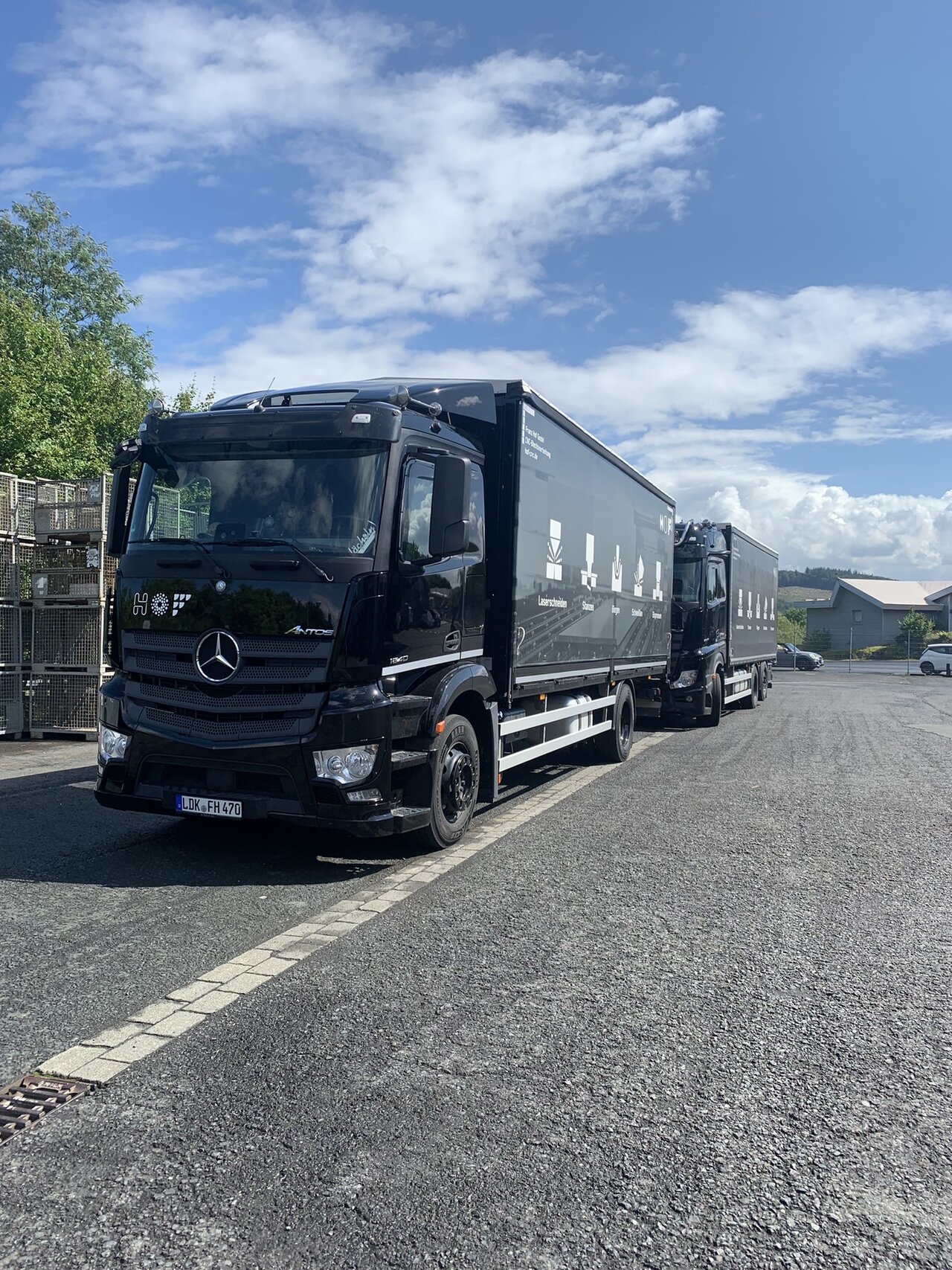 Zwei schwarze HOF-LKW, die hintereinander stehen.