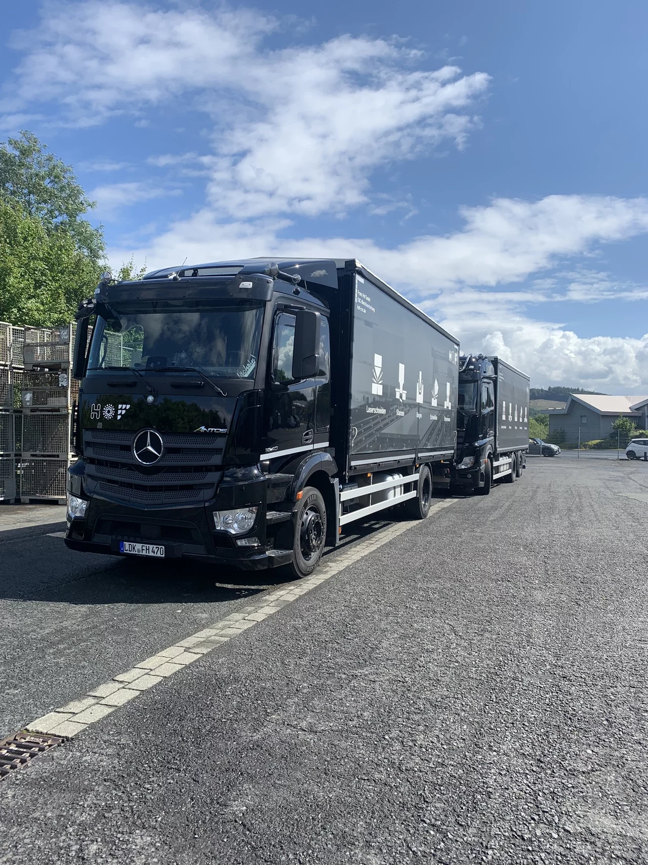 Zwei schwarze HOF-LKW, die hintereinander stehen.