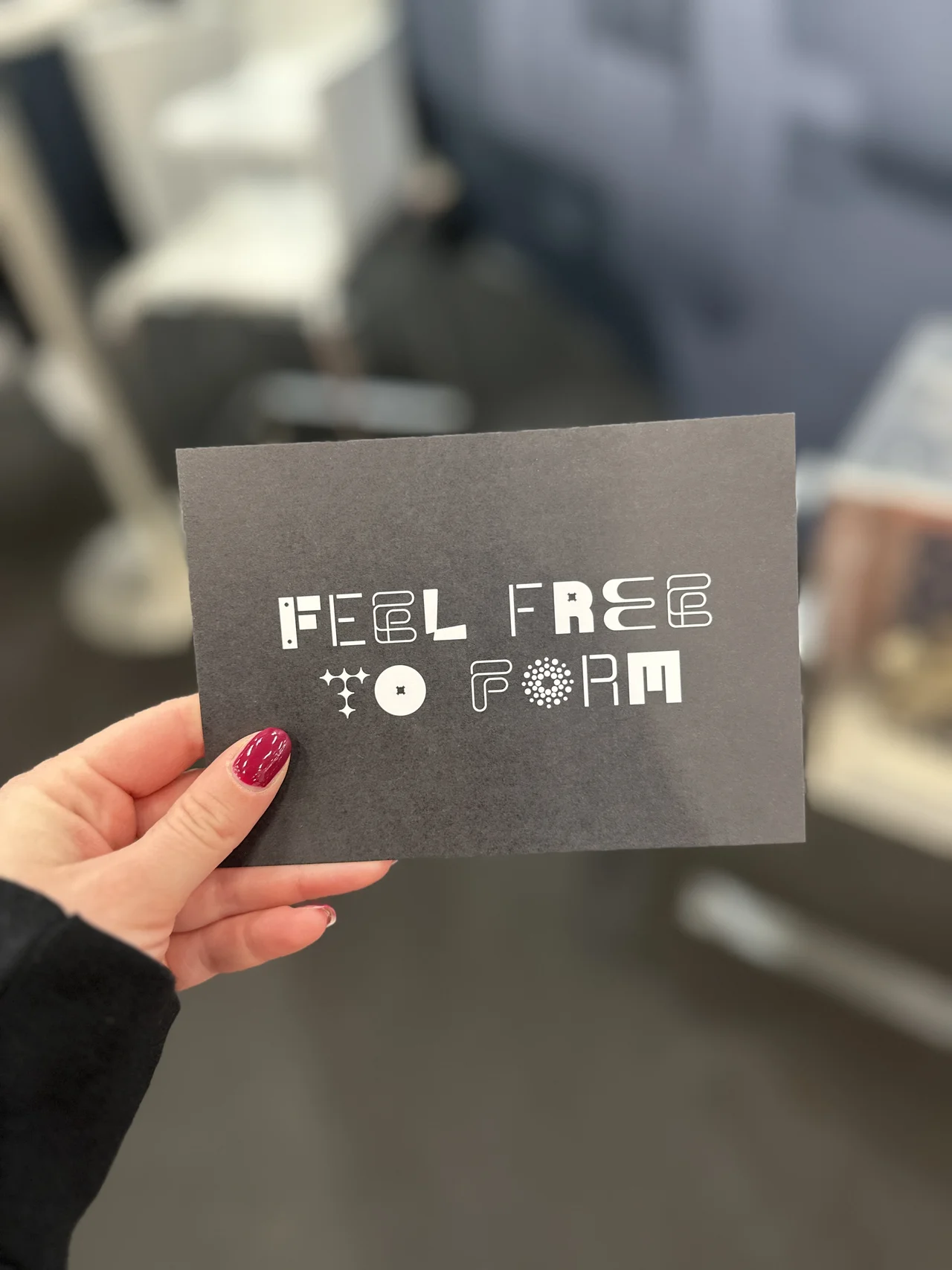 Jemand hält eine Karte von uns mit dem Schriftzug "FEEL FREE TO FORM" hoch.