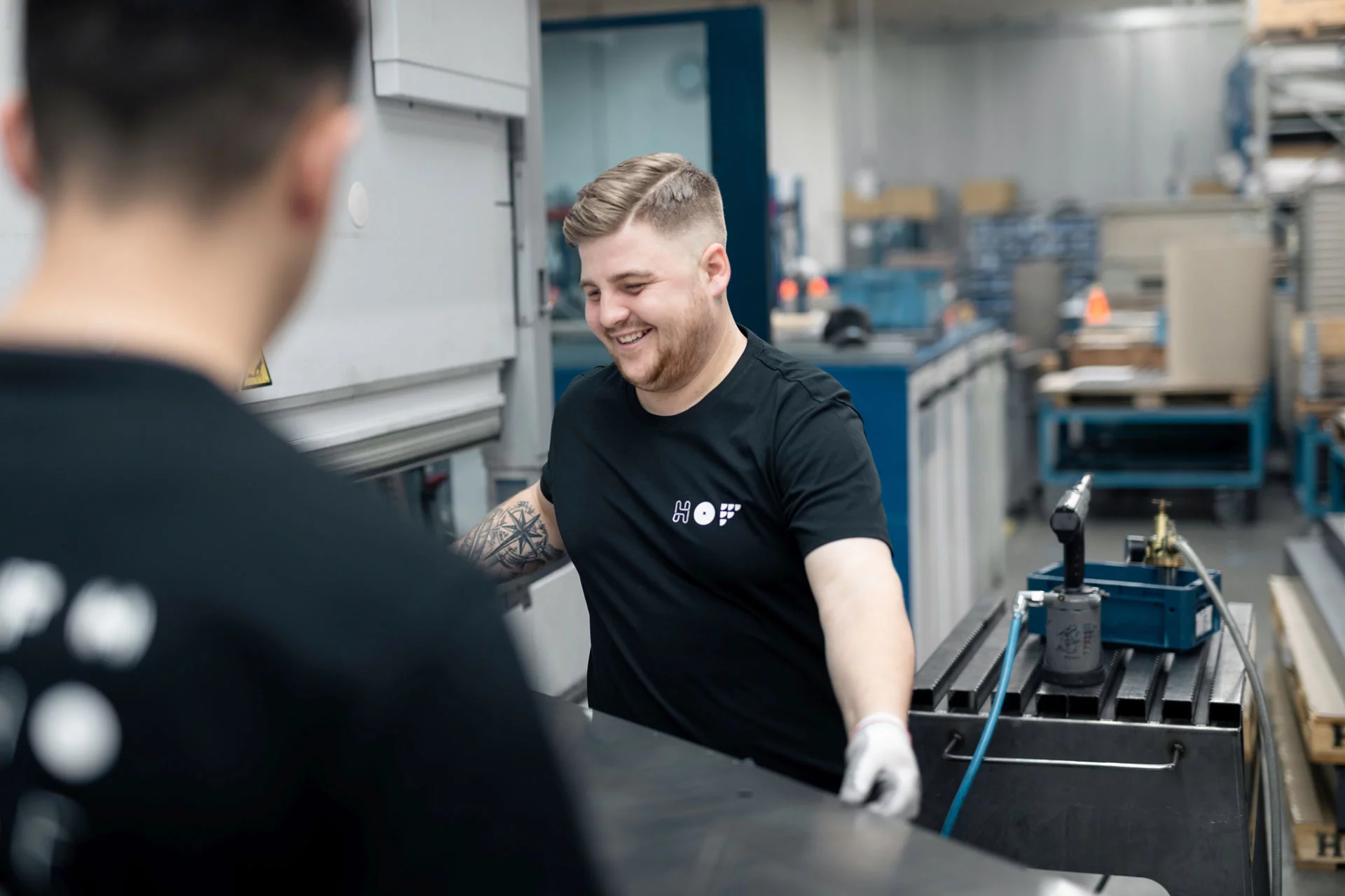 2 HOF-Mitarbeiter beim Kanten von großen Bauteilen.