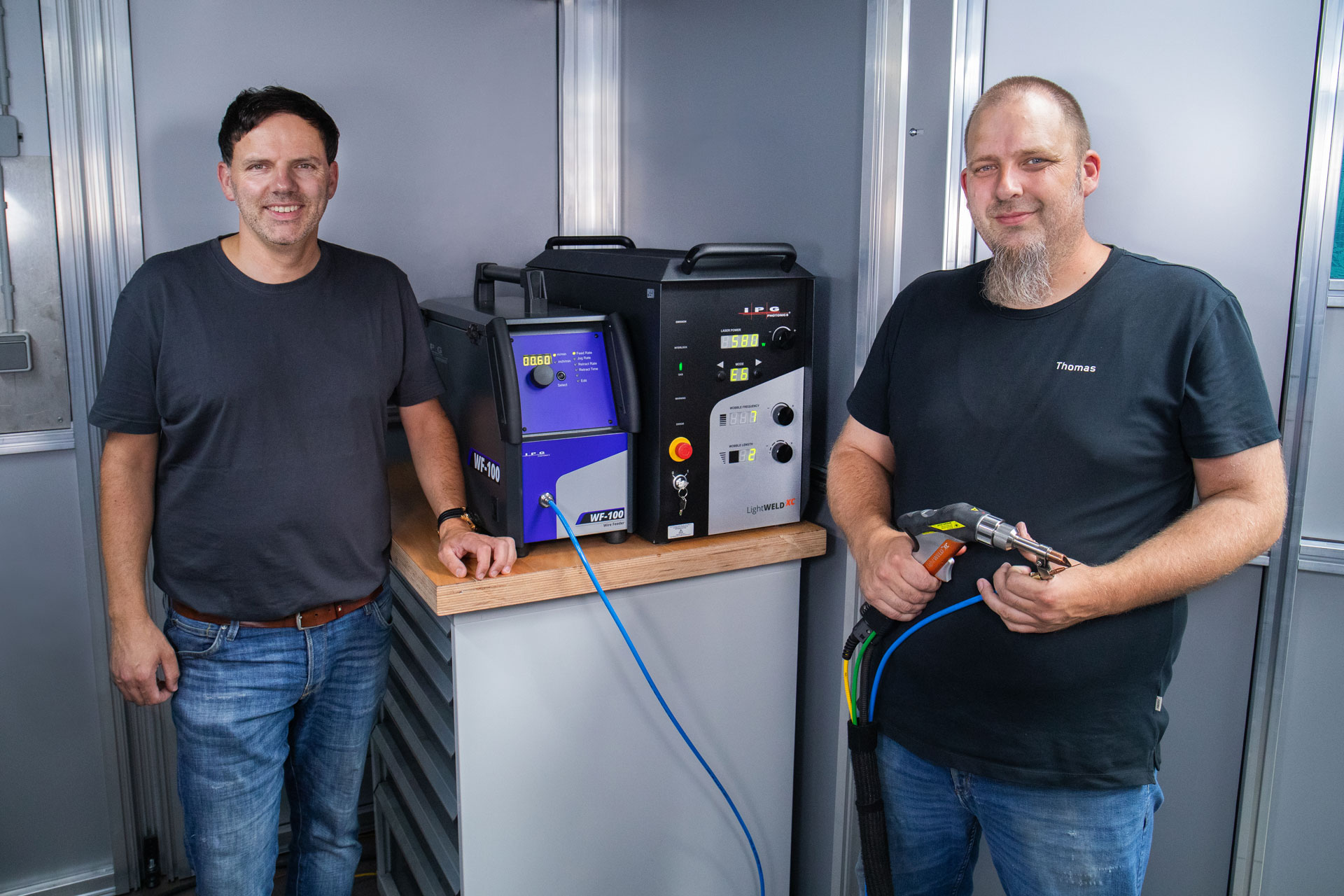 Unser Vertriebspartner Markus Wege und unser Schweißer Thomas stehen vor dem Handlaser.