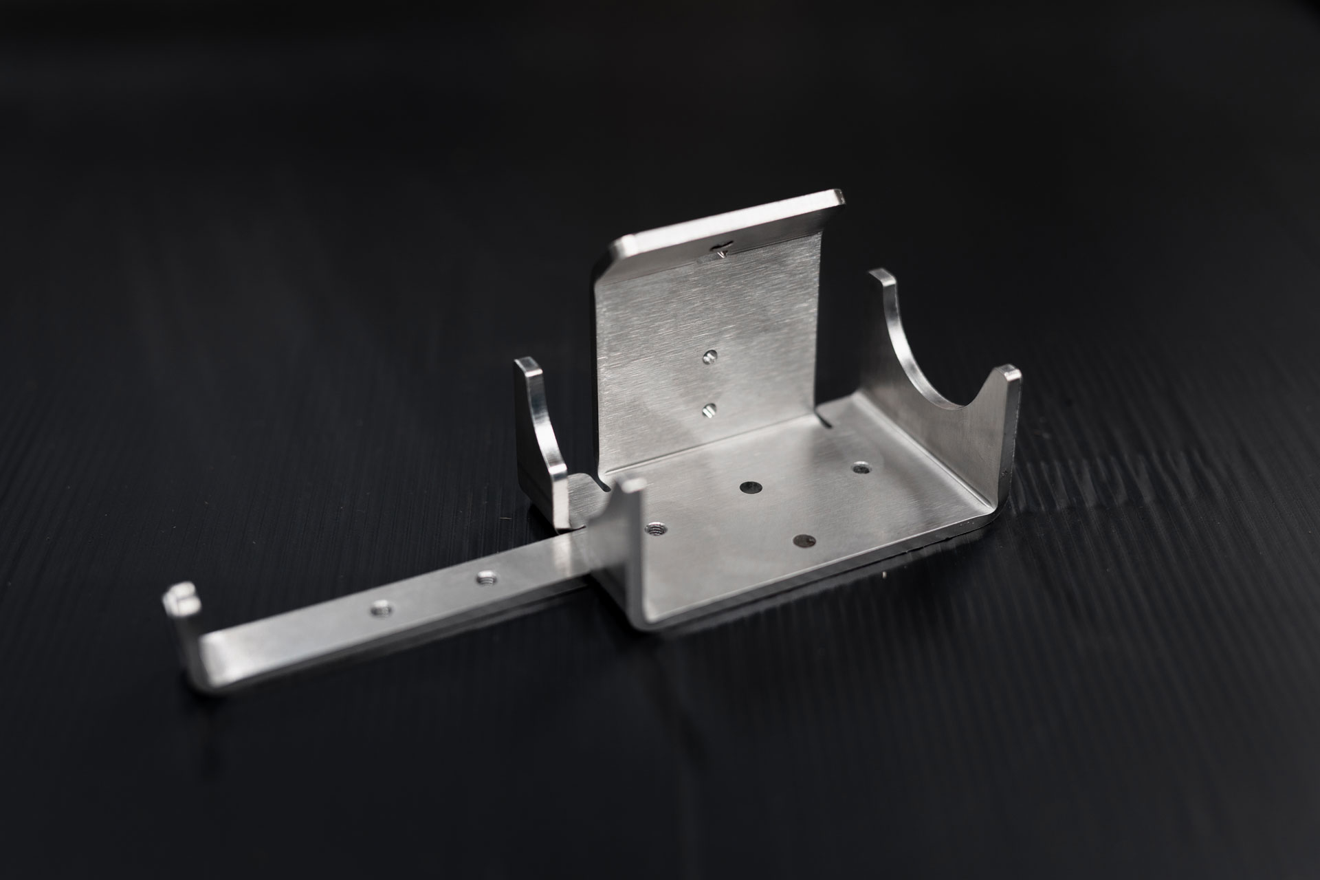 Blechteil aus Edelstahl mit unterschiedlichen Biegeradien und Gewindebohrungen.